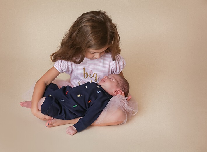 Big sister holding baby brother