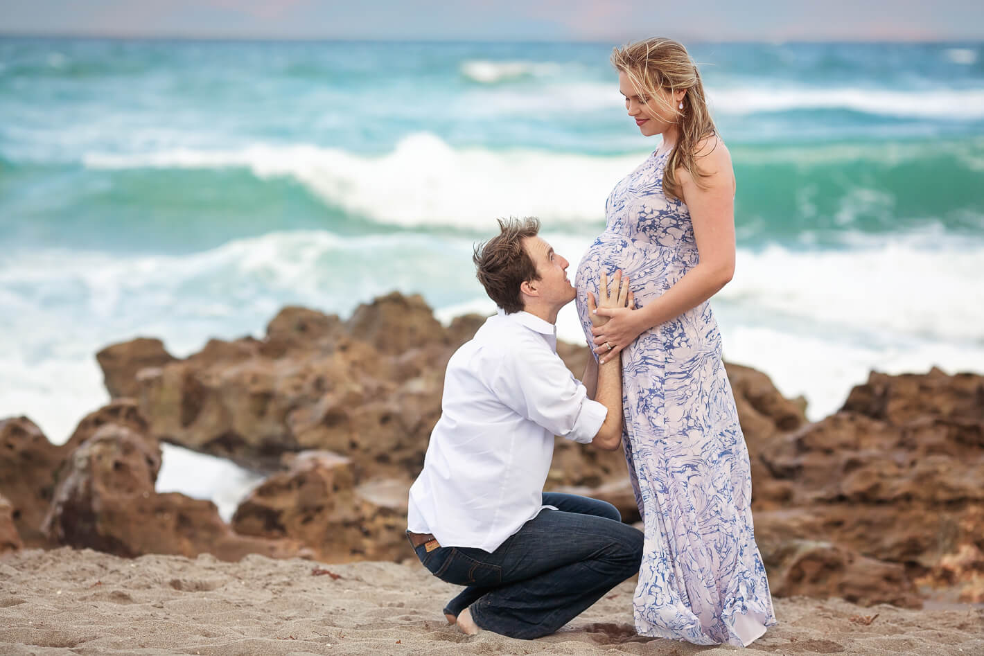 Sweet dad touching mom's belly during maternity session