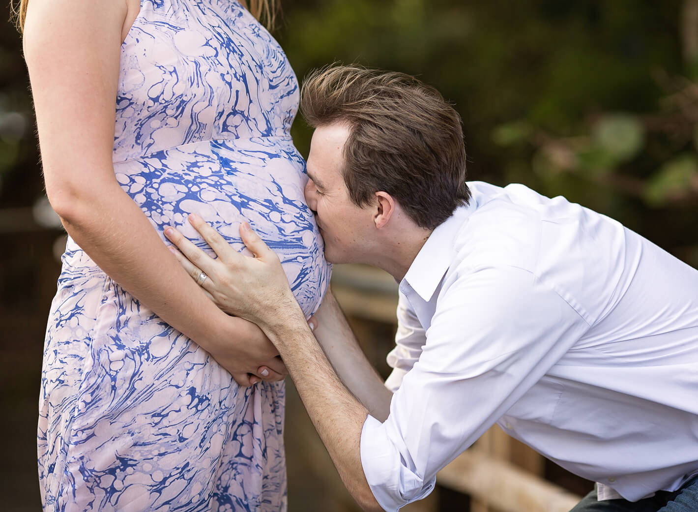 Closeup of dad kissing his wife's belly