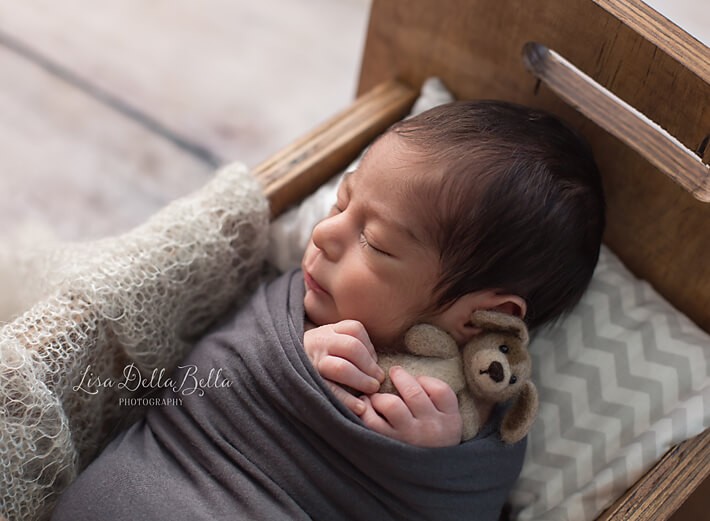 Baby boy in bed with doggie prop