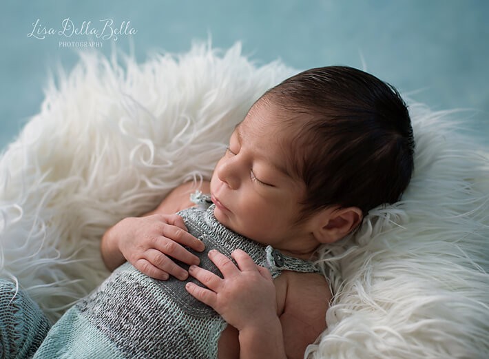 Newborn boy posed in aqua outfit